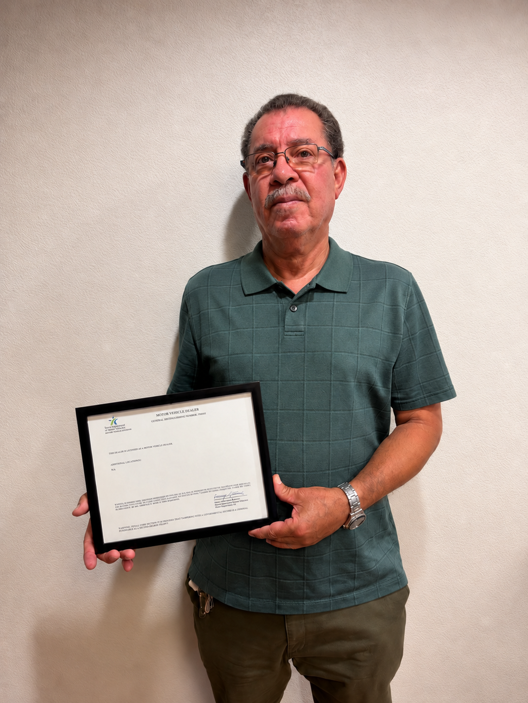 A client of Ricky holding his approved motor vehicle dealer license