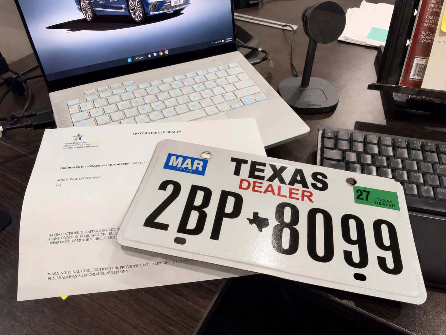 Texas dealer plate and motor vehicle dealer license on an office desk